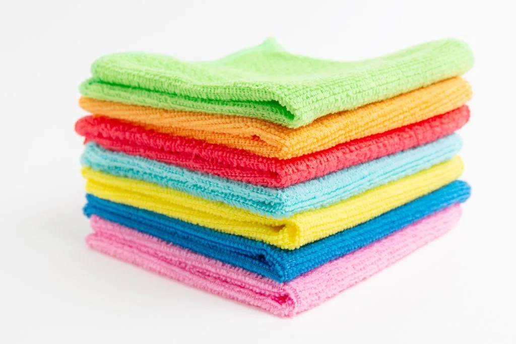 5 Tips to Beat Cabinet Grease Film in the Kitchen 18 A stack of colorful microfiber cloths for cleaning the grease off kitchen cabinets