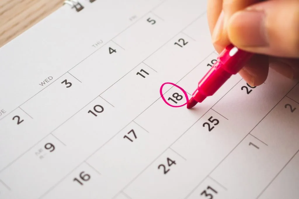 21 Things in Your Home You Should be Throwing Out 16 SOmeone writing on a calendar with a pink pen.