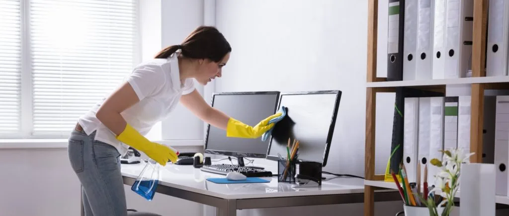 21 Things in Your Home You Should be Throwing Out 17 A woman cleaning a computer screen.