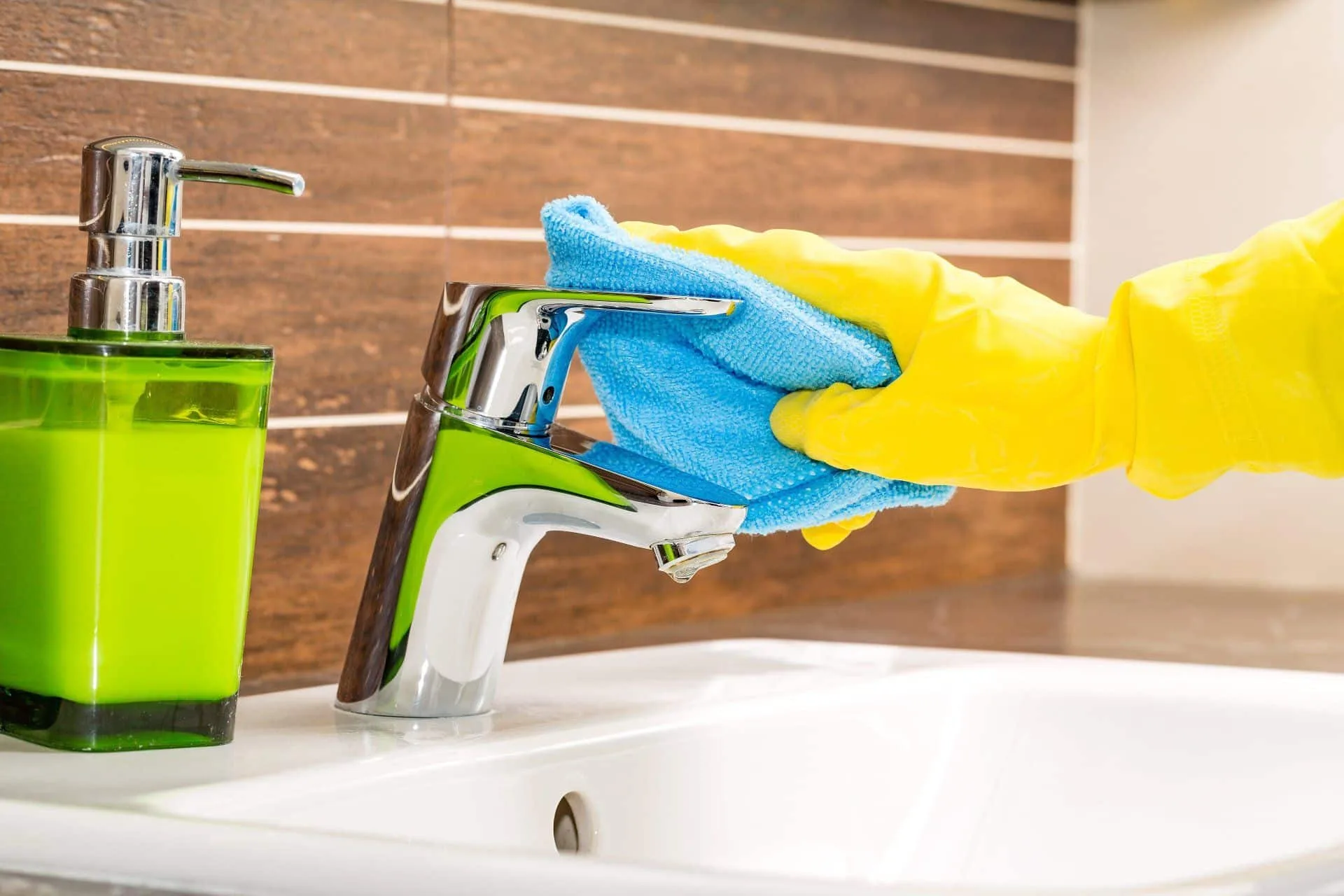 Get Your Cleanest Bathroom Ever 14 a person shining a sink faucet