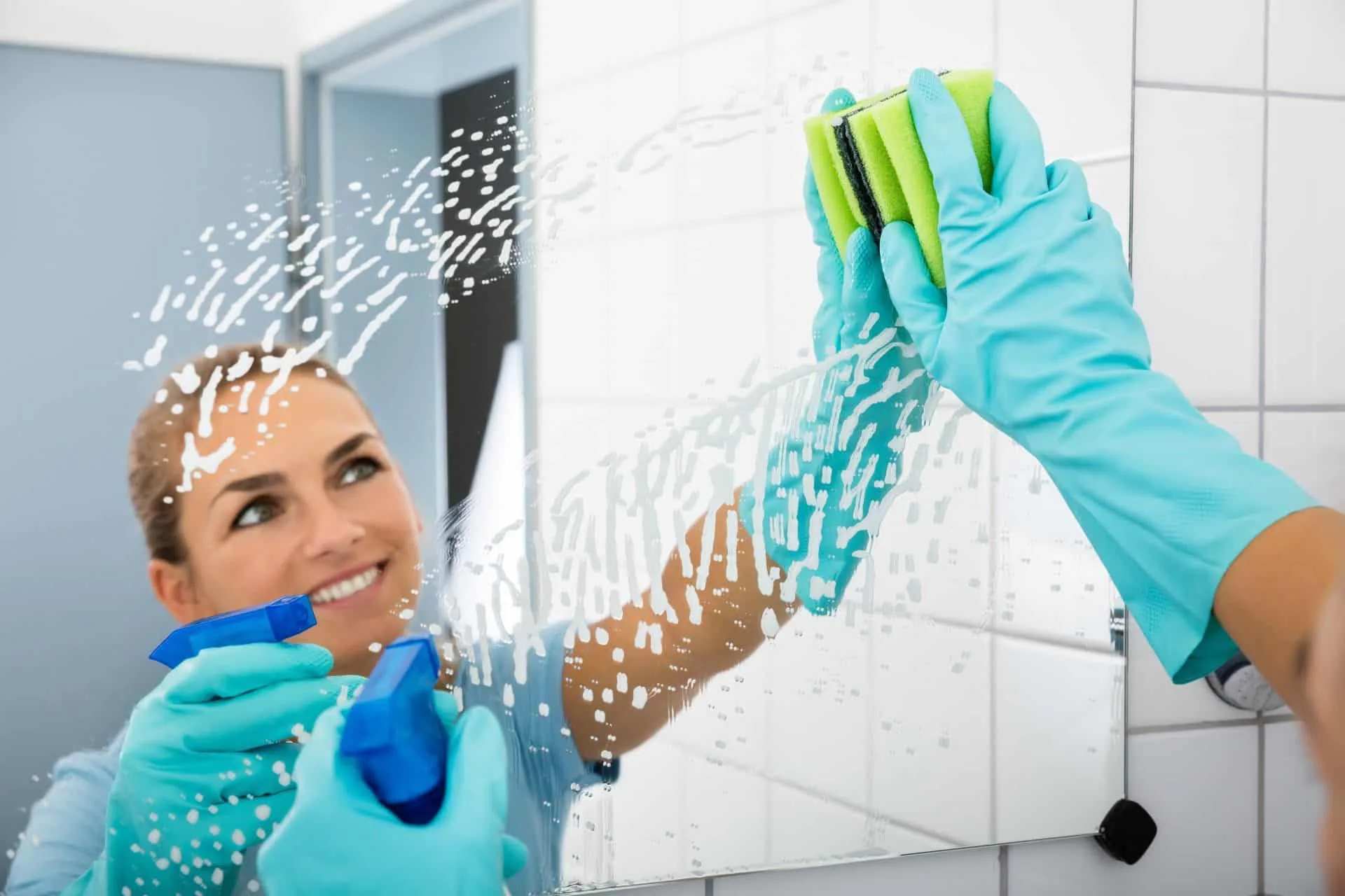 Get Your Cleanest Bathroom Ever 13 woman smiling and cleaning mirror
