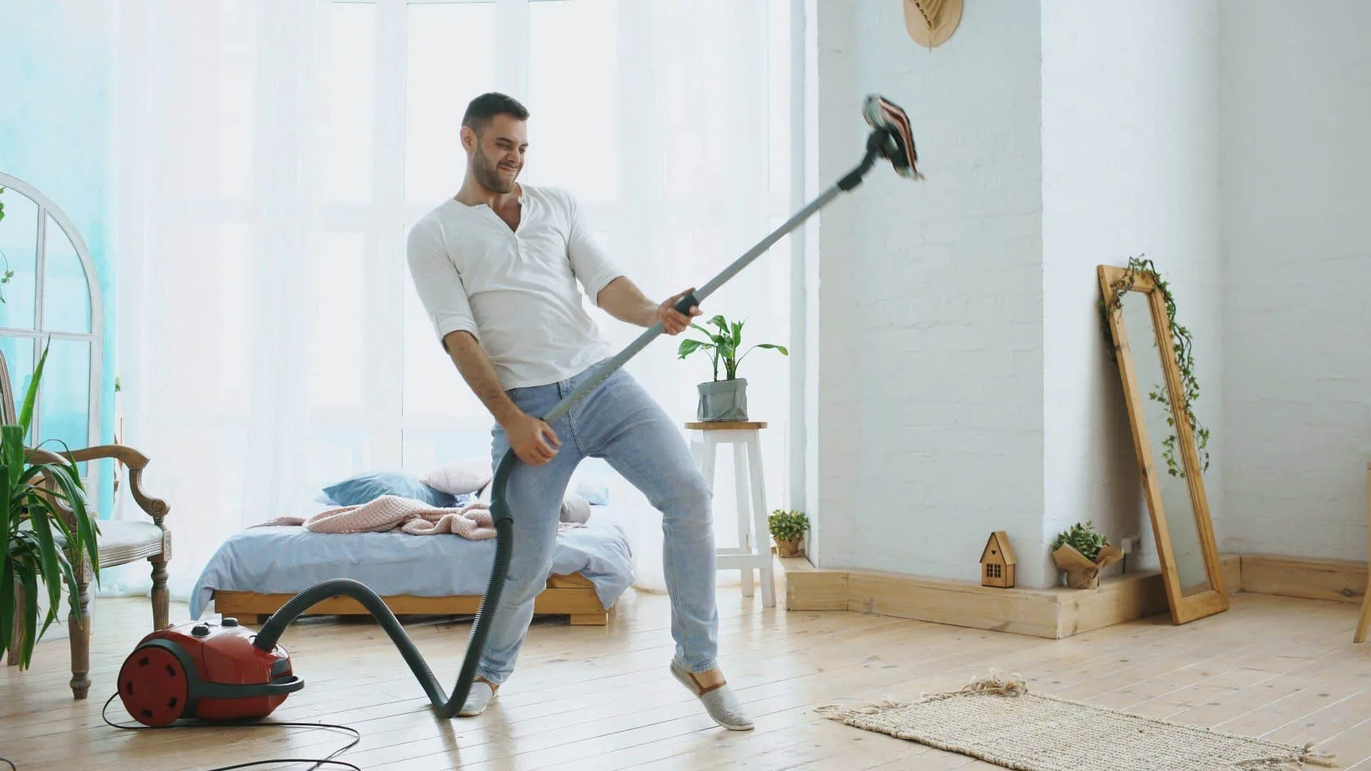 Why Robot Vacuums Can’t Beat Traditional Vacuuming 6 a man playing air guitar on a traditional vacuum