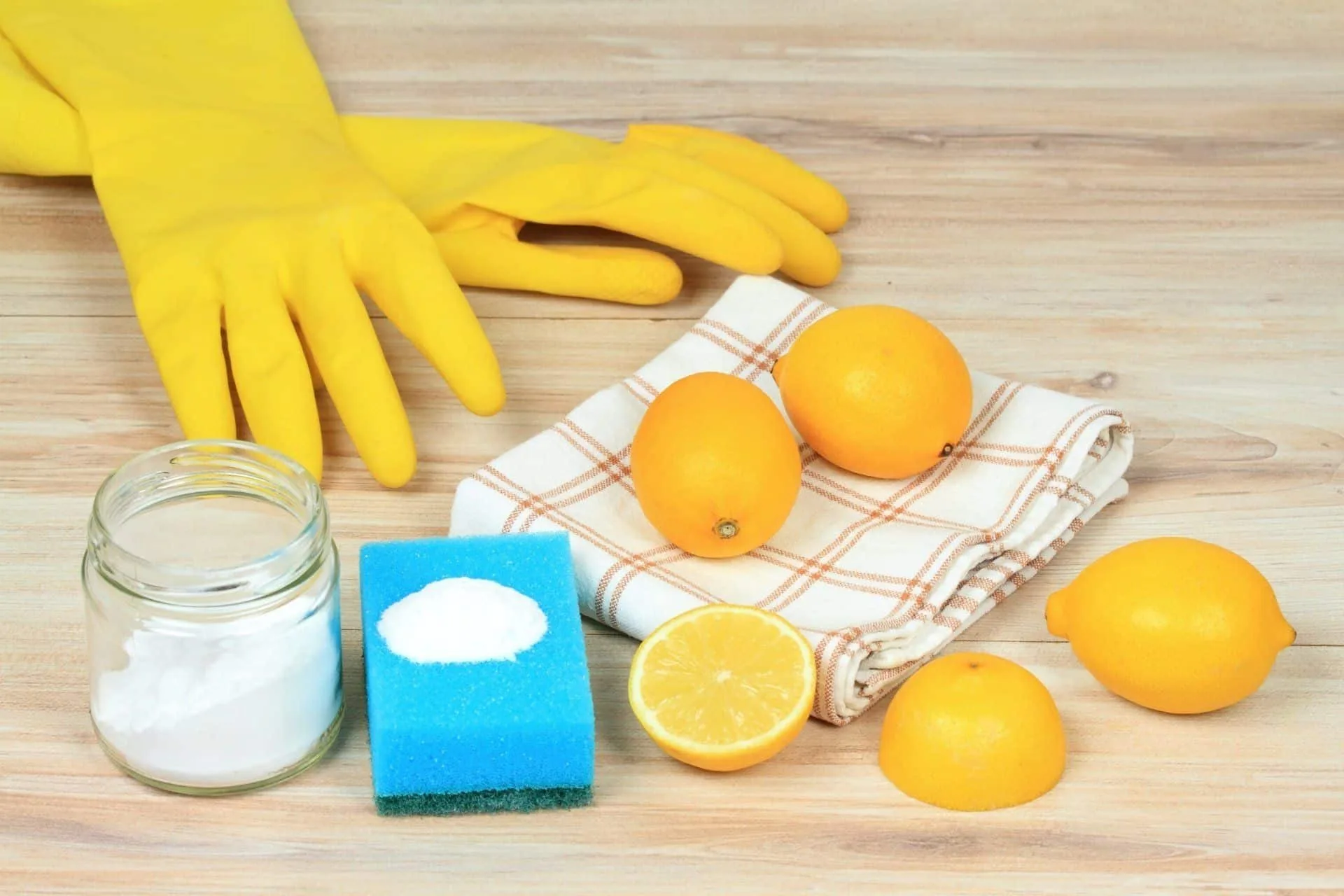 How to Easily Clean Your Home Using Baking Soda 8 yellow cleaning gloves, lemons, dish towel, baking soda and blue sponge