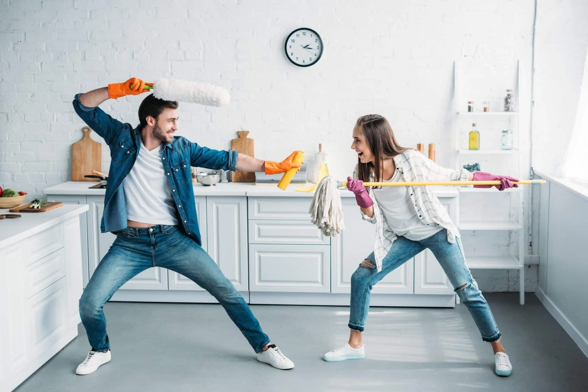 What Cleaning Products Do I Need in My Home? 4 man and woman playfully fighting with cleaning products