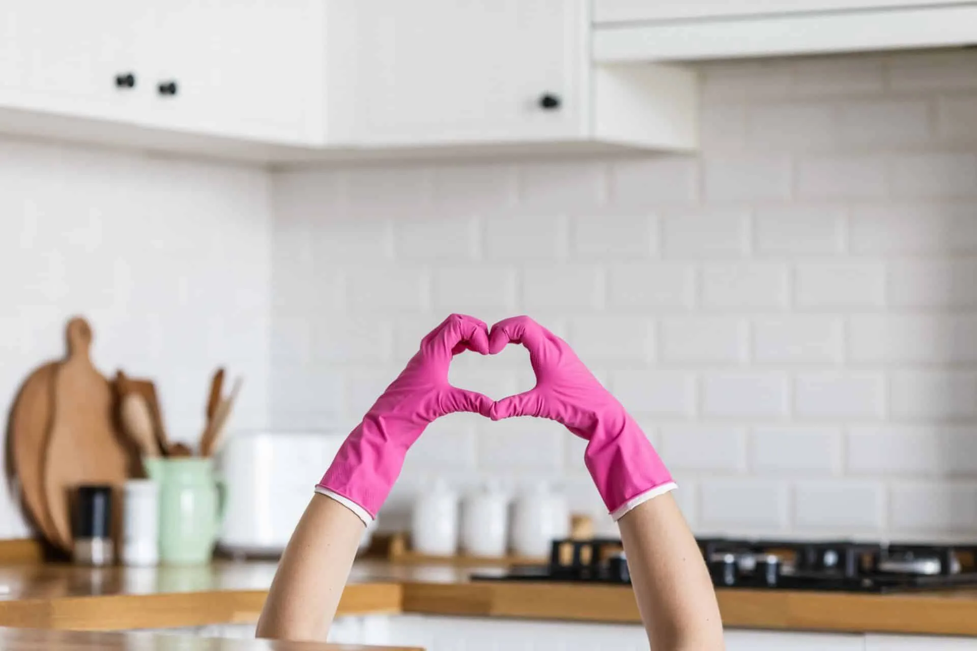 How to Clean Your House Using Bleach 5 a person making the shape of a heart with their hands while wearing pink gloves
