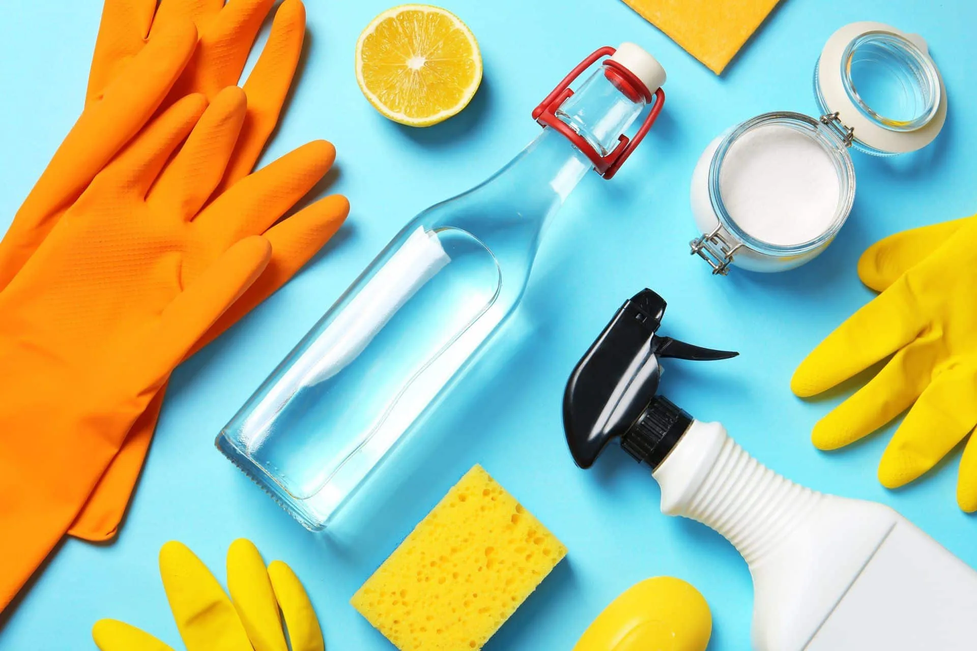How to Easily Clean Your Home Using Baking Soda 12 vinegar, cleaning gloves, spray bottle, baking soda and sponge flat lay