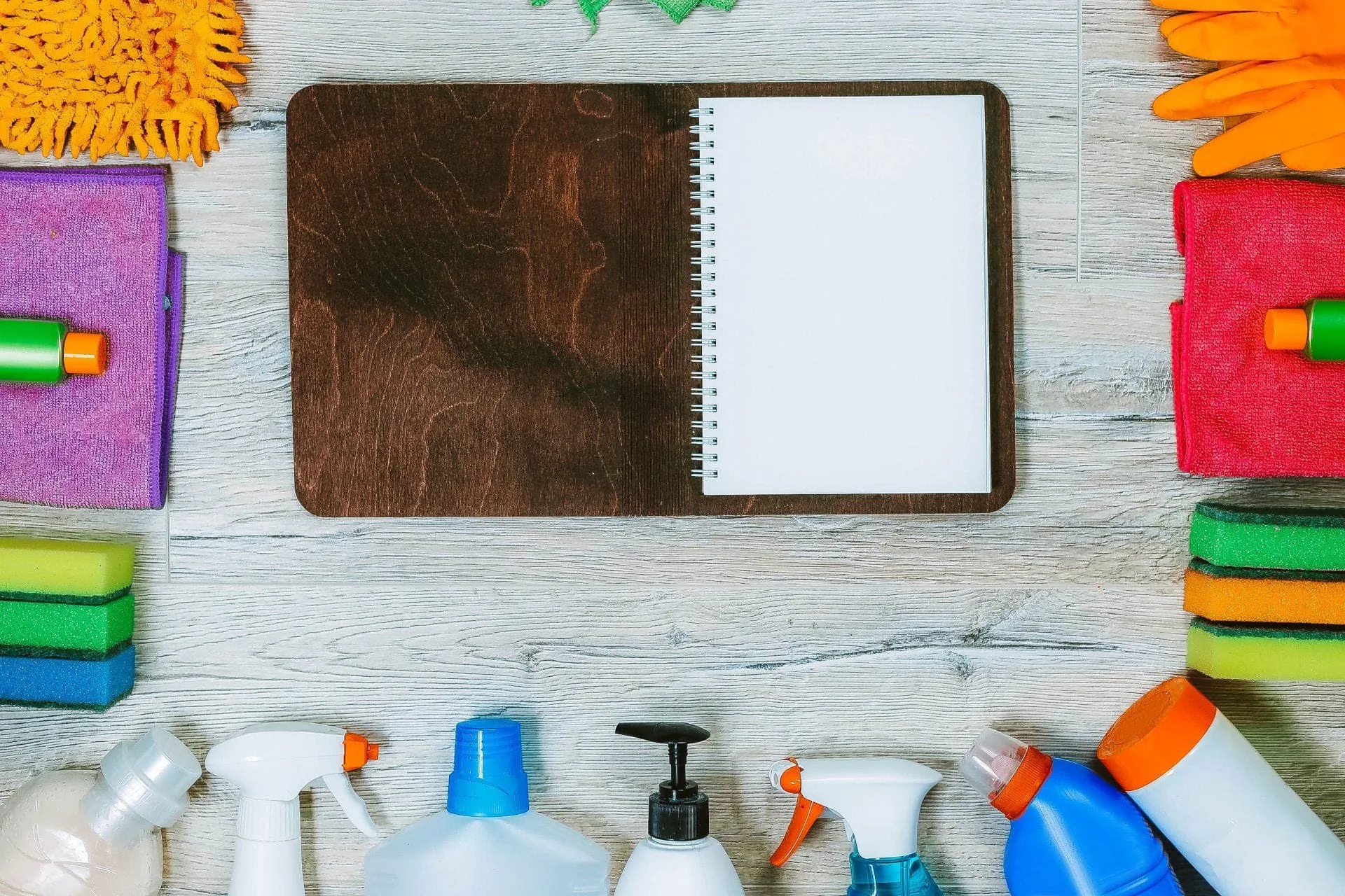 What You Should be Cleaning in Your Home Every Single Day 5 empty open notebook surrounded by cleaning supplies