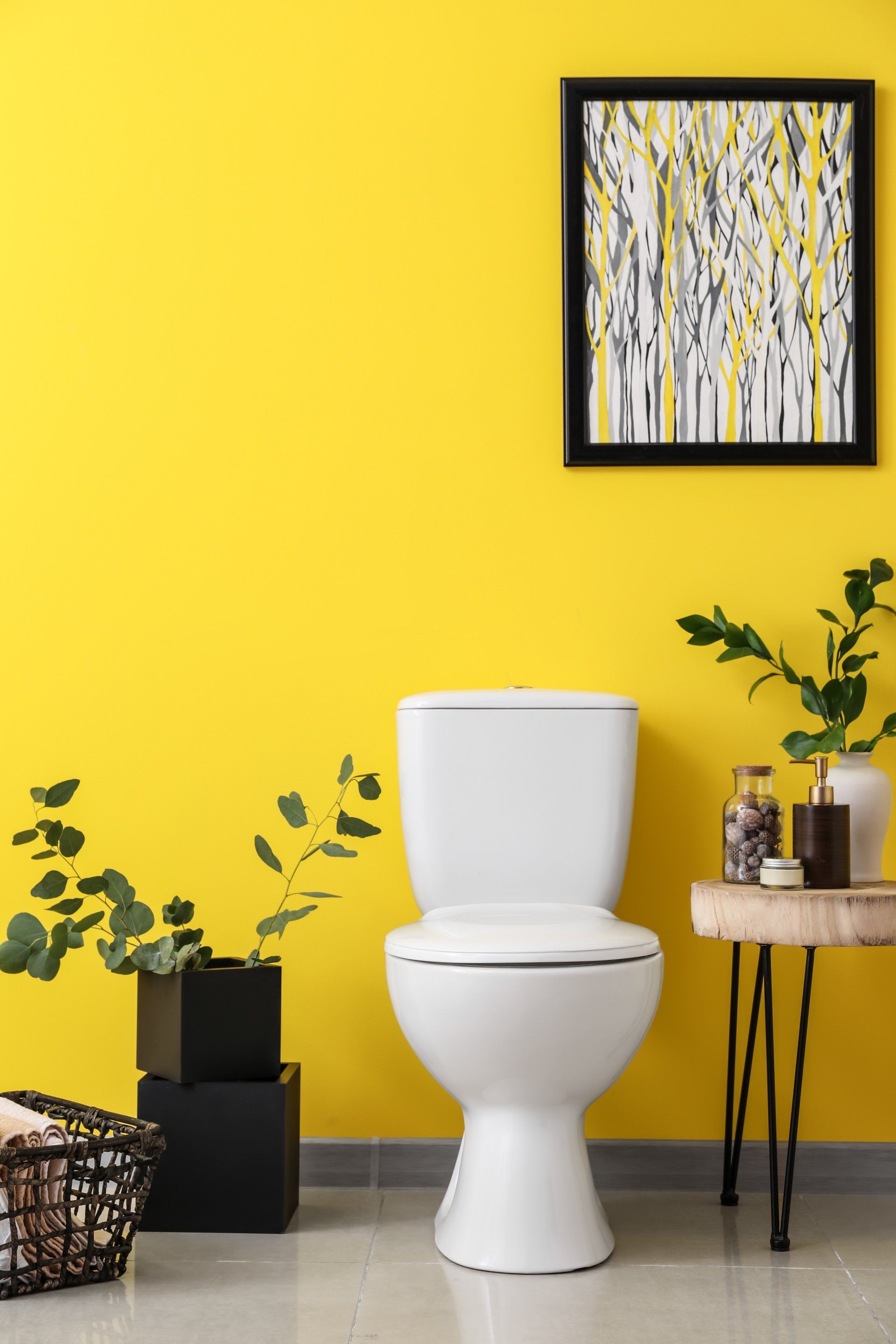 a bathroom with plants, a toilet and yellow walls