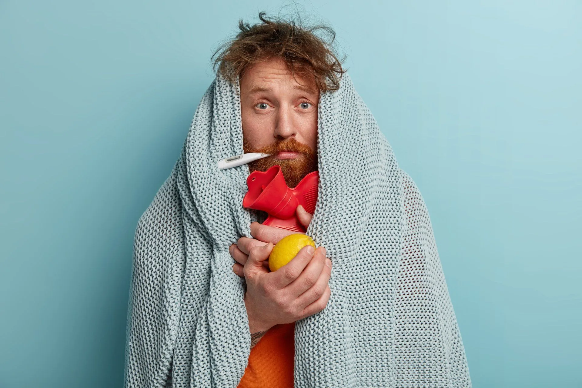 Cleaning with TLC: Your partner in sanitation during COVID-19 4 a man wrapped in a blanket with a thermometer in his mouth because he is sick