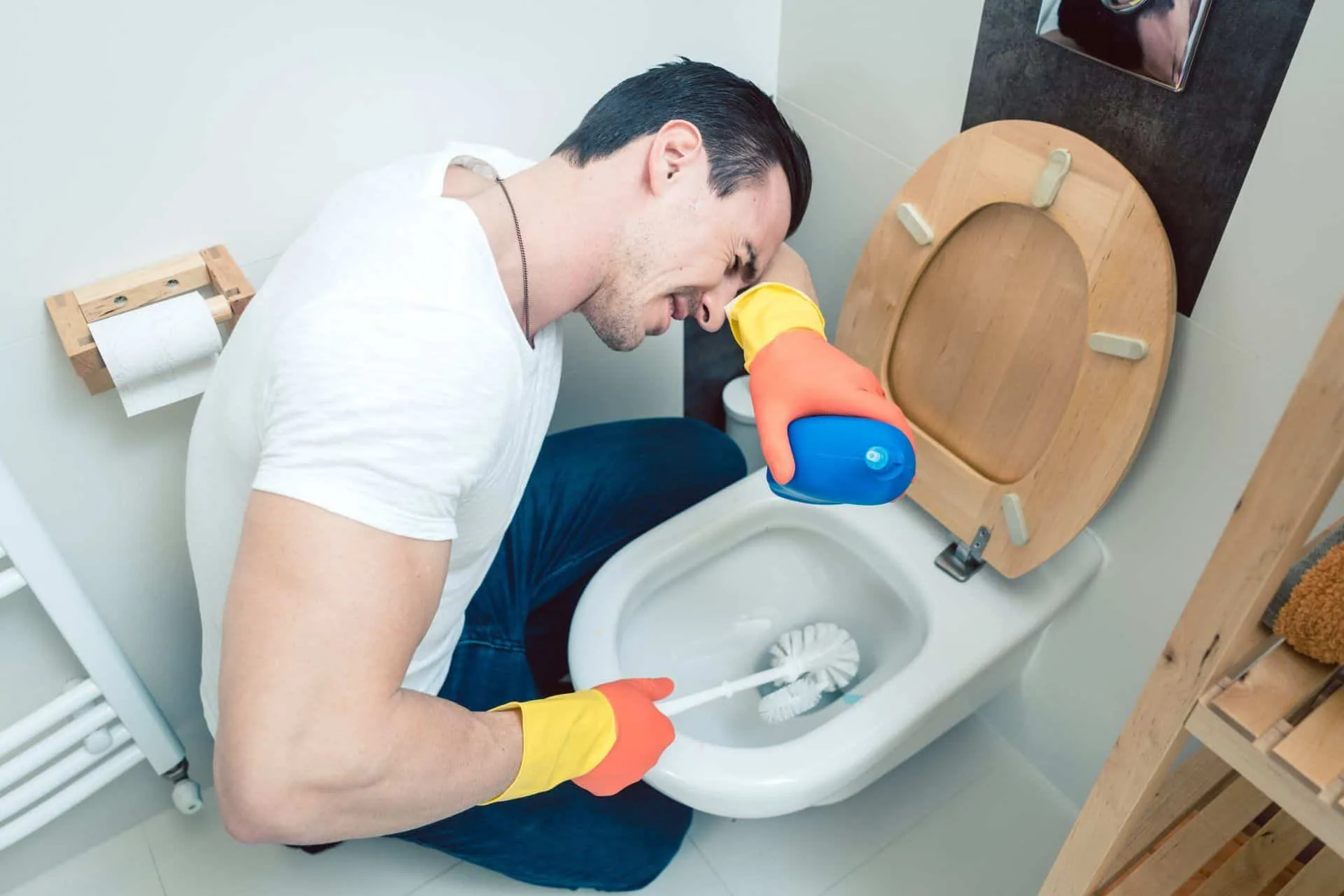 What You Should be Cleaning in Your Home Every Single Day 7 man having a difficult time cleaning a toilet