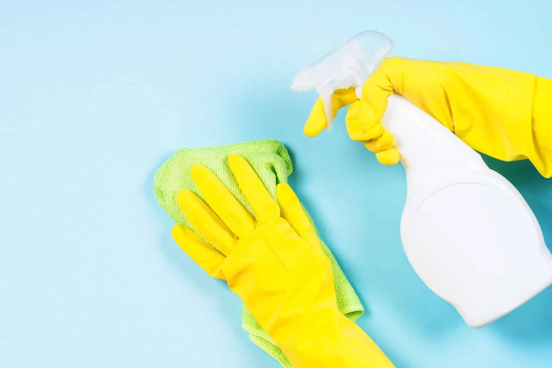 What's the Difference Between Cleaning, Disinfecting and Sanitizing? 11 someone wearing yellow rubber gloves and cleaning with spray and microfiber cloth