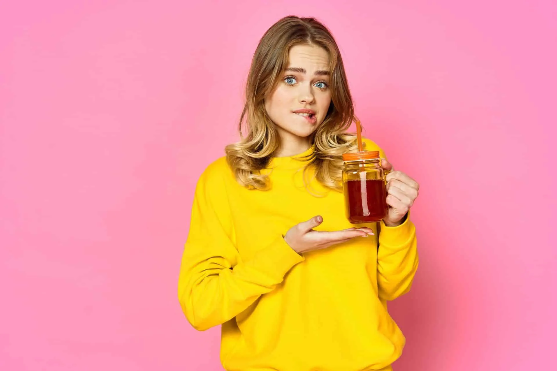 Get Your Cleanest Bathroom Ever 17 a woman on a pink background drinking iced tea