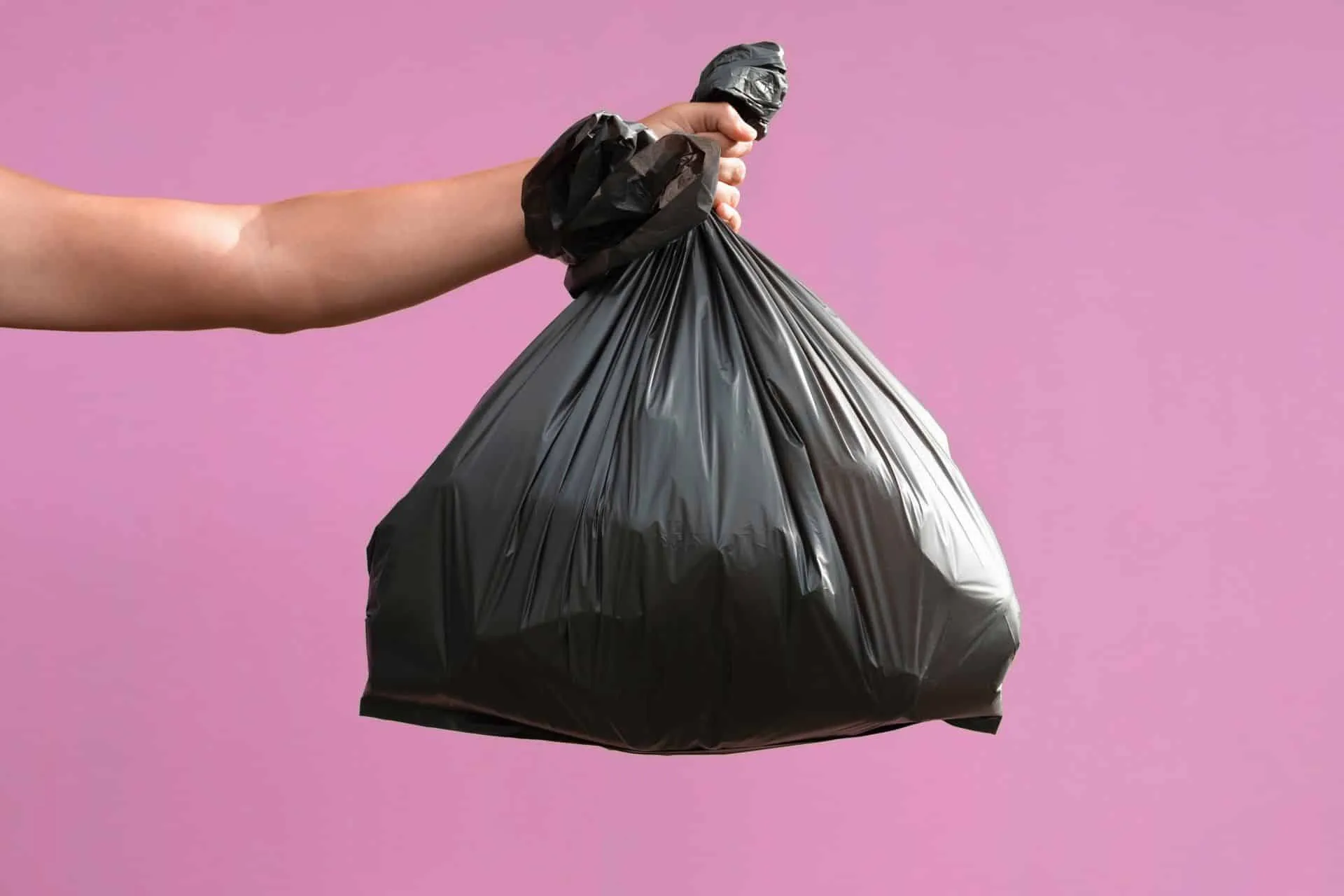 Get Your Cleanest Bathroom Ever 18 someone holding a full black trash bag