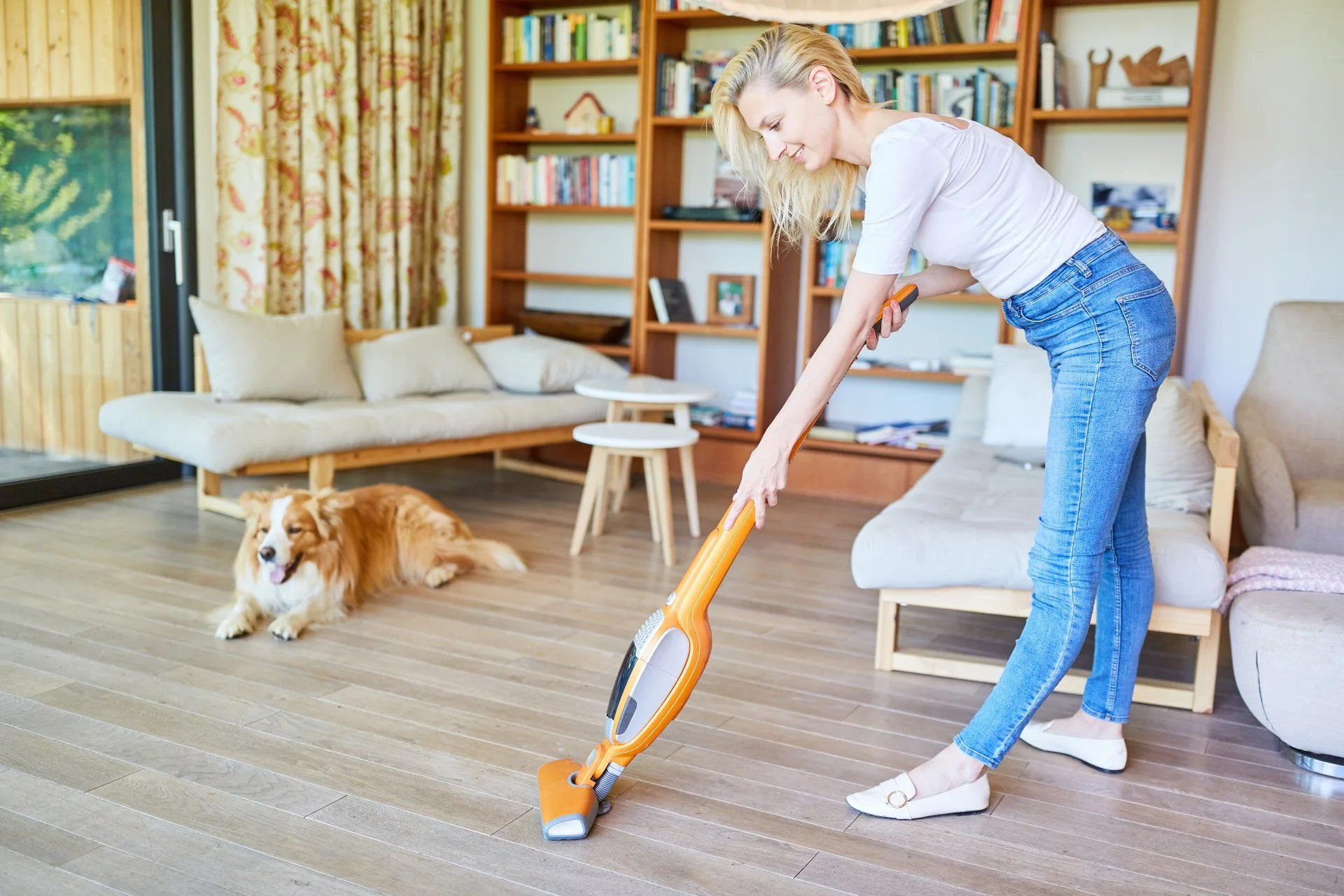 Why Robot Vacuums Can’t Beat Traditional Vacuuming 2 woman vacuuming with a dog in the background