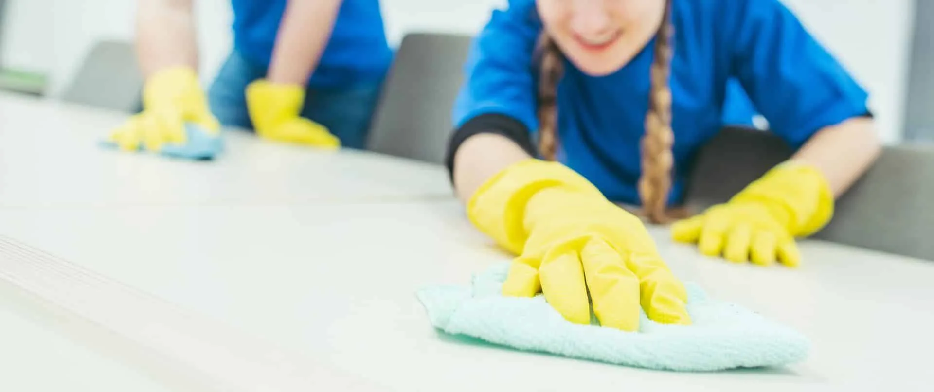 Cleaning with TLC: Your partner in sanitation during COVID-19 2 people with yellow rubber loves cleaning a surface with microfiber towels