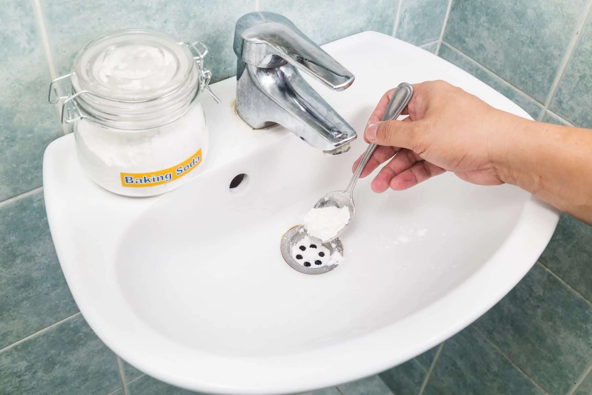 How to Easily Clean Your Home Using Baking Soda 10 someone pouring baking soda down a bathroom sink drain