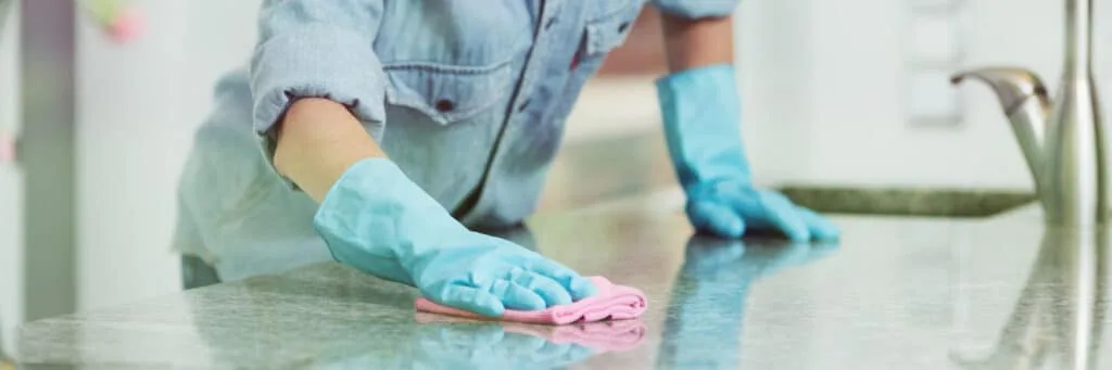 5 Hall Closet Organization Tips 9 Someone wiping off a counter in cleaning gloves