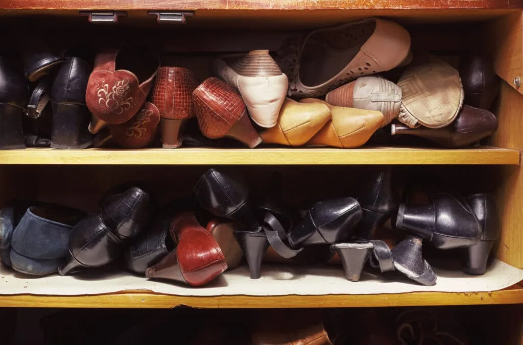 5 Hall Closet Organization Tips 3 Cluttered shoes on shelves in a hall closet. View these tips for the best hall closet organization.