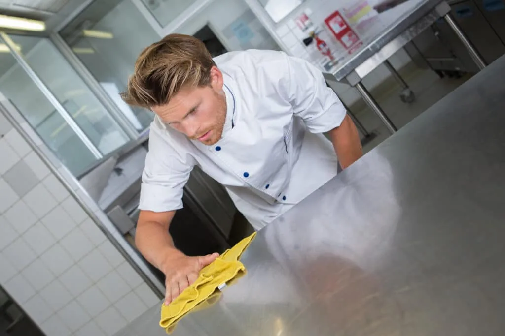Like New: How to Clean a Stainless Steel Sink 9 male chef cleaning stainless steel kitchen work surface
