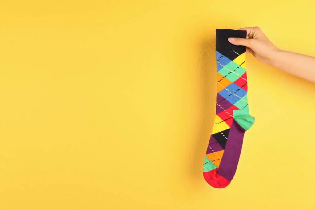 How to Clean Baseboards 11 Woman holding bright sock and space for design on color background