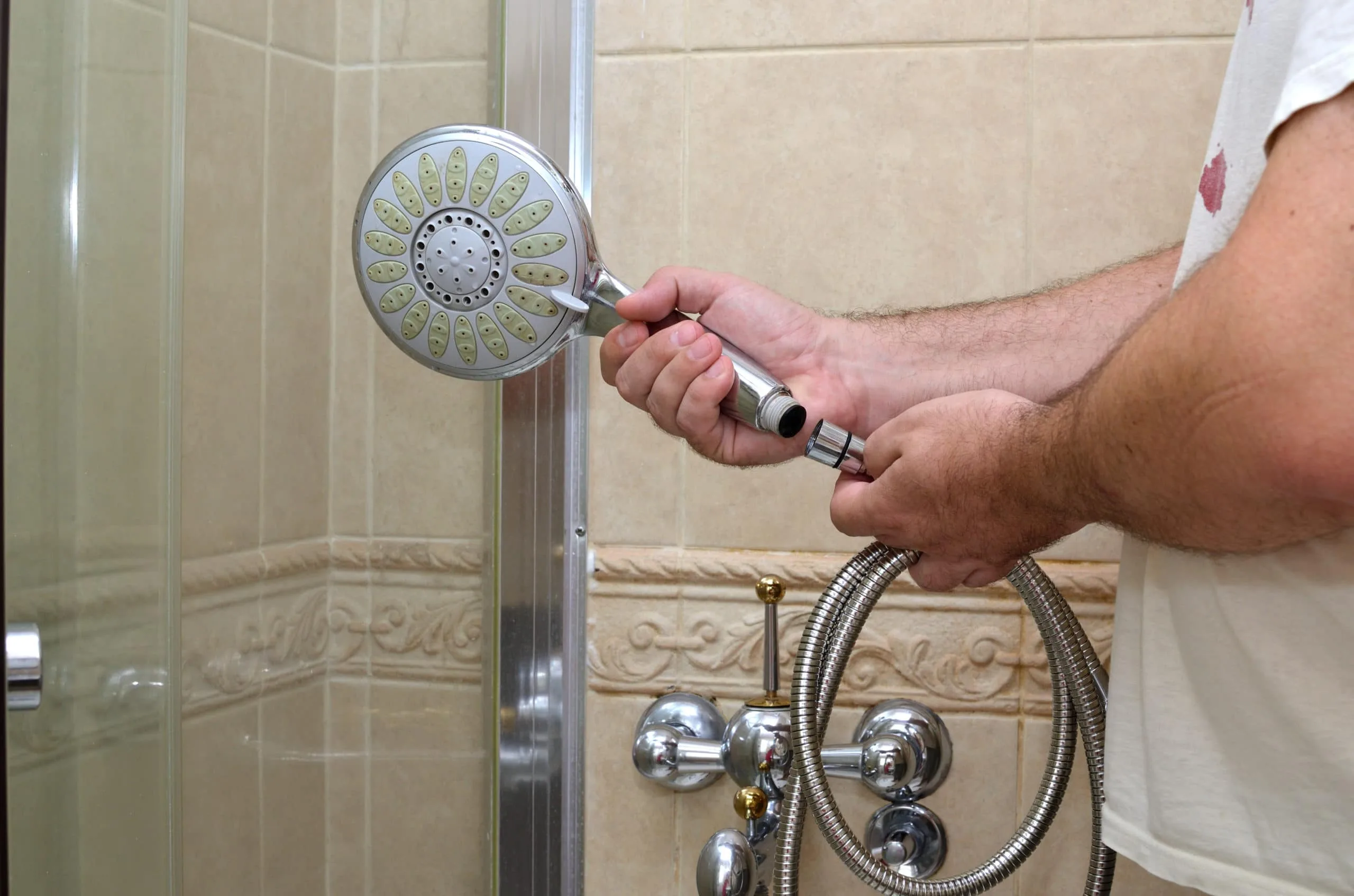 How to Clean a Shower Head 7 Someone removing a showerhead to learn how to clean a showerhead