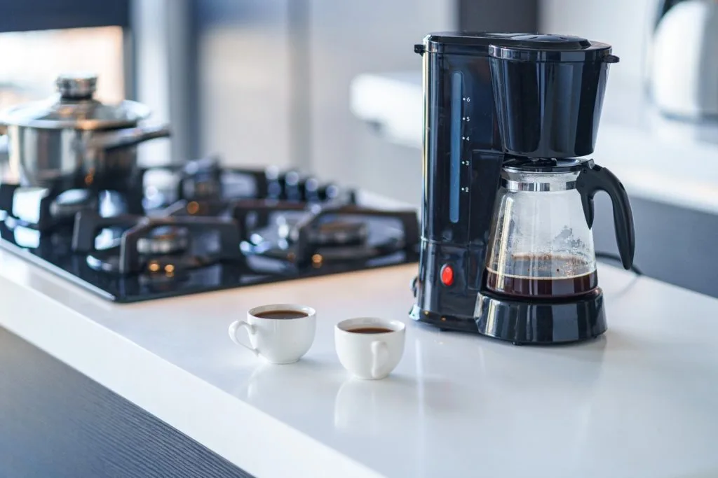 Learn How to Clean a Room in 5 Minutes 9 A coffee pot brewing coffee for guests.