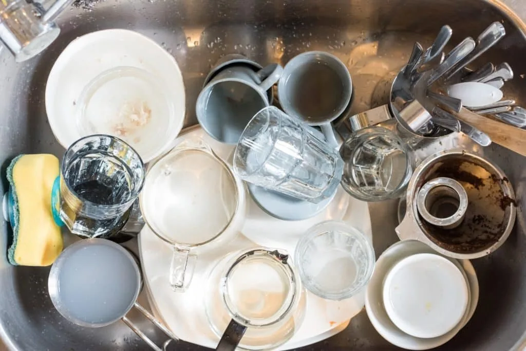 Learn How to Clean a Room in 5 Minutes 4 A sink full of dirty dishes that need to be washed.
