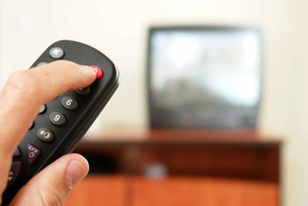 Learn How to Clean a Room in 5 Minutes 3 Someone turning off the TV with a remote in preparation to learn how to clean a room in 5 minutes