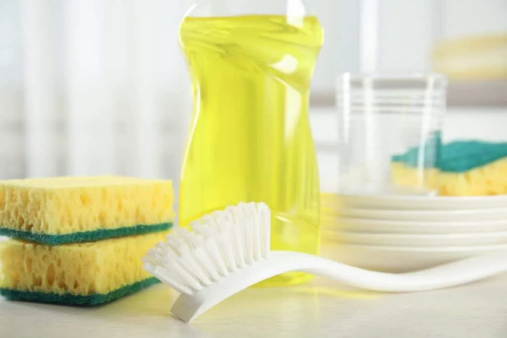 How to Clean Your House Cleaning Tools 5 A dish brush with sponges and dish soap.