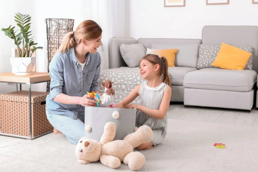 These 7 Chores for Kids Let You Delegate the Housework 3 A mom and child cleaning up toys together.