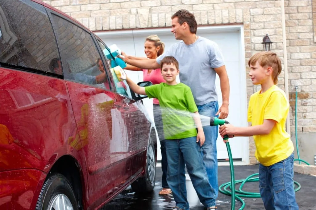 These 7 Chores for Kids Let You Delegate the Housework 7 A family of four washing their red van.