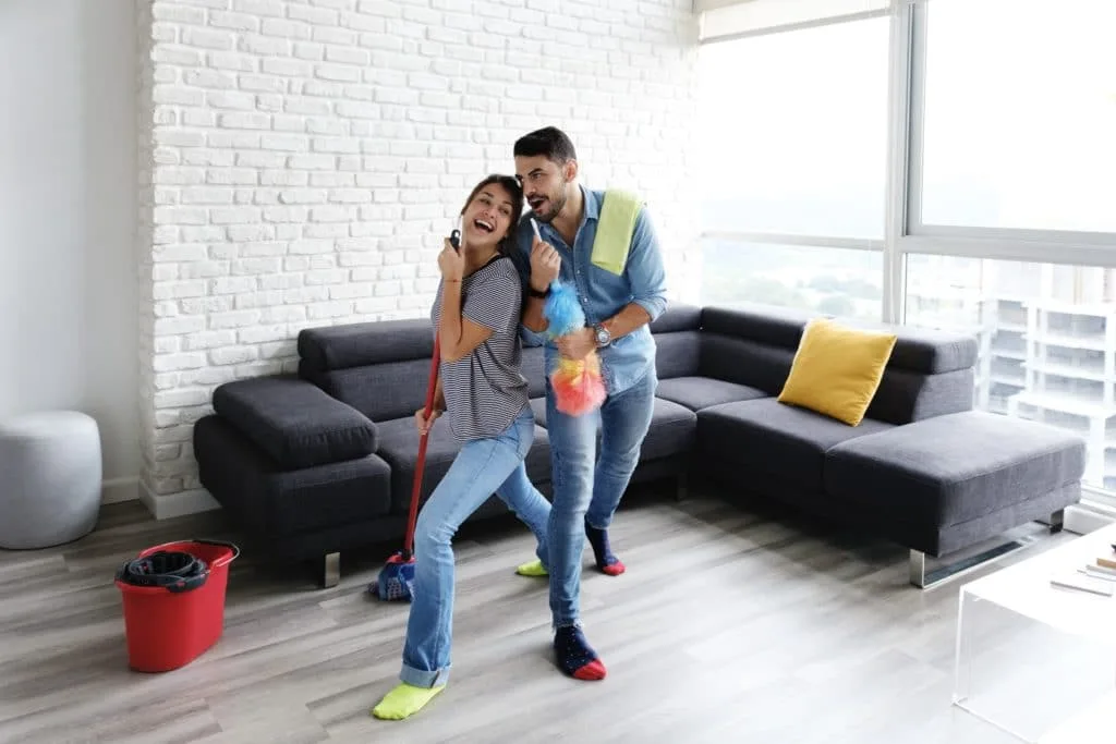 13 Things to Try and Make Cleaning Fun 8 Couple singing and cleaning while blasting music to make cleaning more fun.