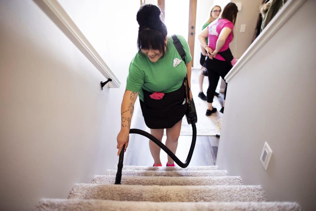 A cleaning professional vacuuming stairs as part of a move-in cleaning service, ensuring the home is spotless for new occupants.