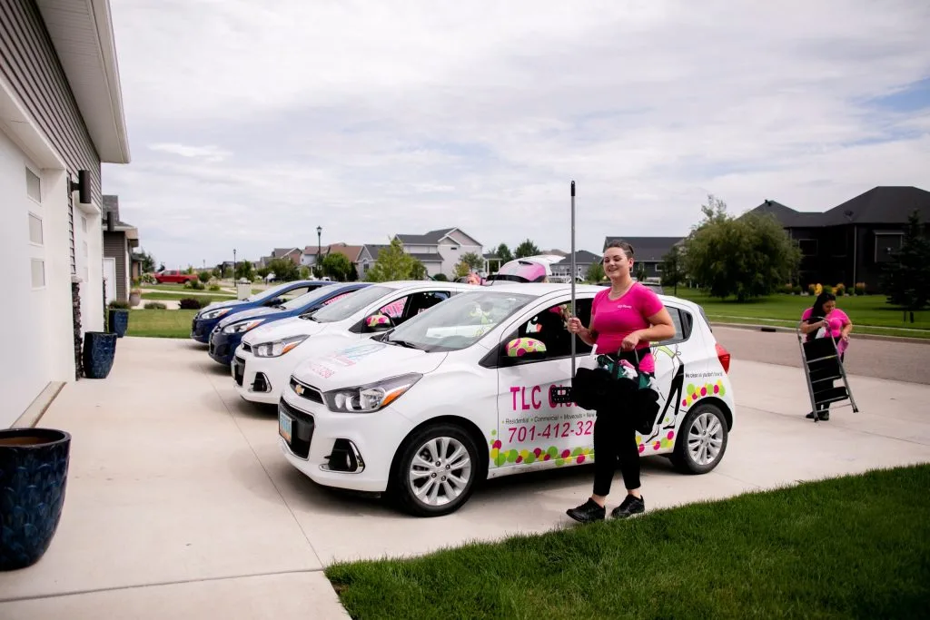 Top Bathroom Cleaning Tips for a Sparkling Fresh Lavatory 1 TLC Cleaning crew preparing for a job with branded company cars parked in a residential driveway, showcasing their professional cleaning services.